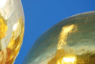 Low angle view of balloons against clear blue sky