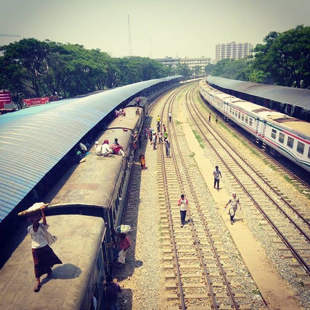 transportation, railroad track, rail transportation, the way forward, high angle view, railroad station platform, public transportation, travel, mode of transport, diminishing perspective, large group of people, built structure, railroad station, men, person, architecture, vanishing point, incidental people, city