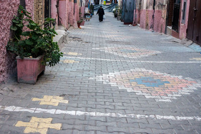 Low section of woman walking on footpath in city