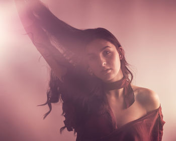 Portrait of young woman against gray background