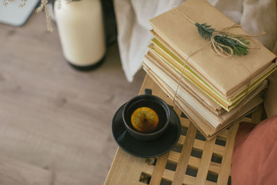 High angle view of lemon tea by stack of books on table