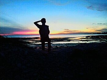 People standing on beach at sunset