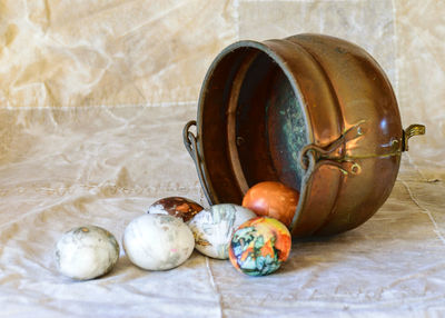 Ancient copper bowl with colored eggs, celebration of easter, still life