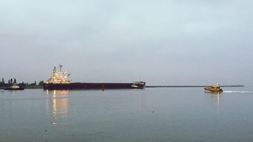 Ship sailing on sea against sky