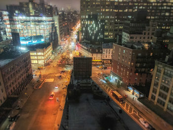 High angle view of illuminated city street and buildings at night