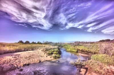 Scenic view of river against cloudy sky