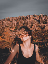 Portrait of beautiful woman against rock formation