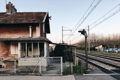 Railroad tracks amidst buildings against clear sky
