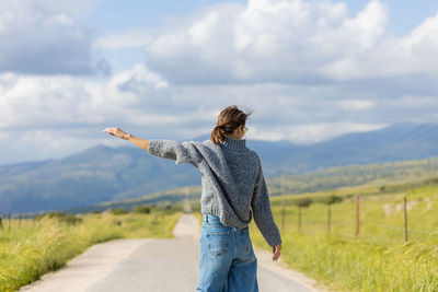 Rear view of woman standing against sky