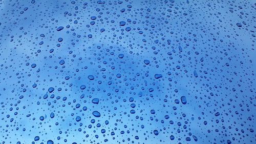 Full frame shot of water drops against blue sky