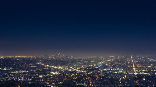 High angle view of illuminated city against sky at night
