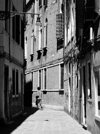 People walking on alley amidst buildings in city