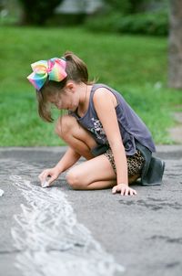 Girl drawing on footpath