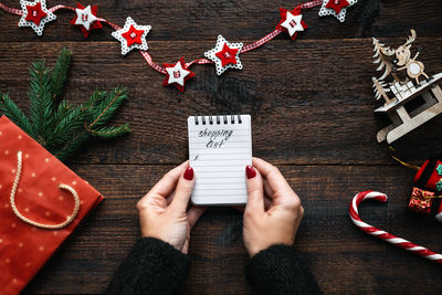 Christmas shopping list. christmas shopping on budget. christmas money saving tips. female hands