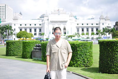 Portrait of smiling man standing against building in city