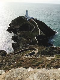 Scenic view of rocks by sea against sky