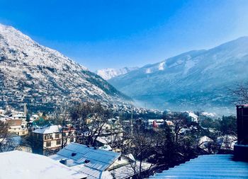 High angle view of townscape by mountains during winter