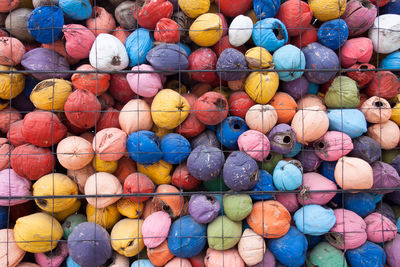 Full frame shot of multi colored coconuts seen through fence