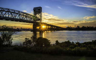 Bridge over river against sky during sunset