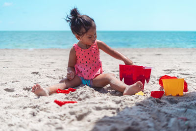 Rear view of woman sitting at beach