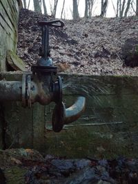 Close-up of metal pipe against trees