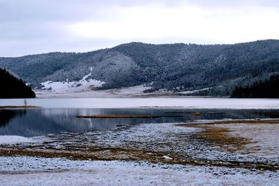 Scenic view of lake against sky during winter