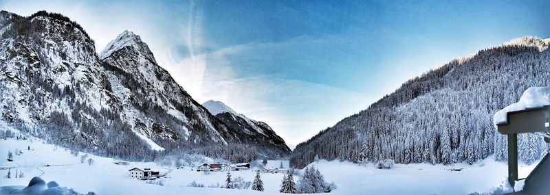 Panoramic view of snow covered mountains against sky