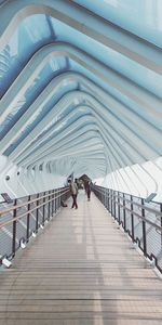 Rear view of people walking on footbridge