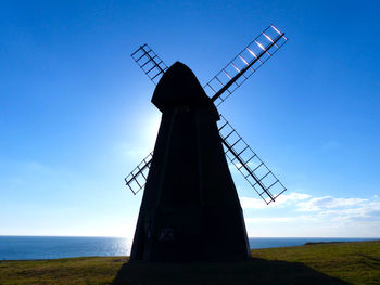 Traditional windmill on field against sky