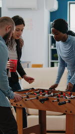 Business colleagues playing foosball at office