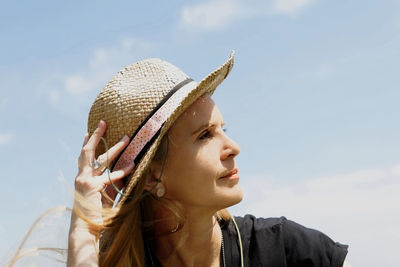 Close-up of woman wearing hat against sky