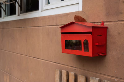 Close-up of red mailbox on wall of building