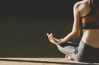 Low section of woman sitting in lotus position
