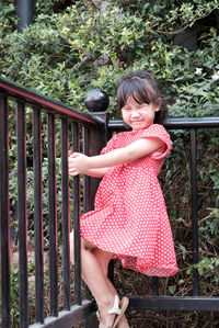 Side view of girl standing by railing