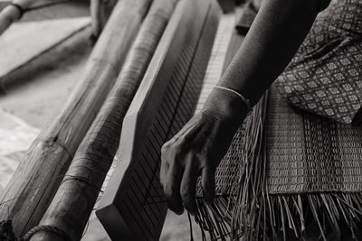 Cropped hand of woman weaving on loom