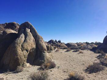 Rock formations in desert against clear blue sky