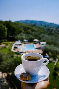 Close-up of coffee cup against sky