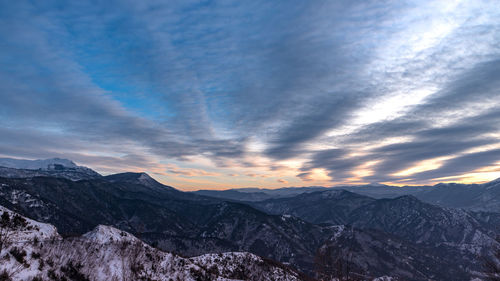 Scenic view of snowcapped mountains against sky during sunset