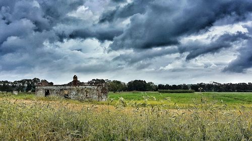 Scenic view of field against cloudy sky