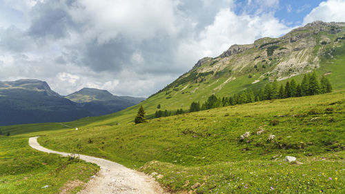 Scenic view of road amidst mountains against sky