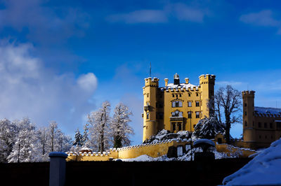 Low angle view of buildings against cloudy sky