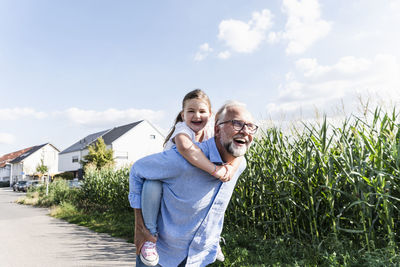 Grandfather carrying granddaughter piggyback