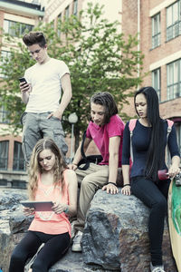 High school students using technologies at schoolyard