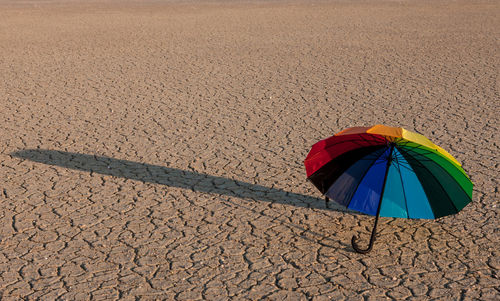Multi colored umbrella on sand