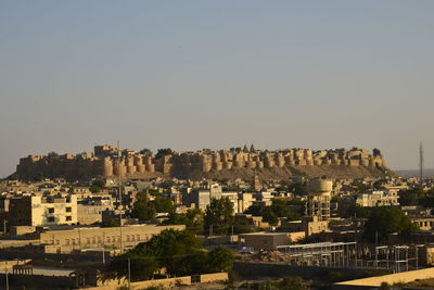 Houses in city against clear sky