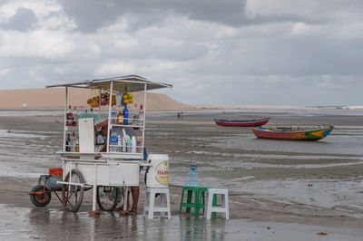 Fishing boats on beach against sky