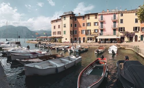 Boats moored at harbor by buildings in city