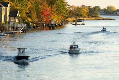 Boat sailing in river against sky during autumn