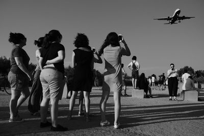 Group of people on runway against sky