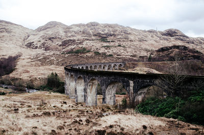 Old train bridge against rock mountain